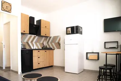 a kitchen with a refrigerator and a table at le studio du Grazel in Gruissan