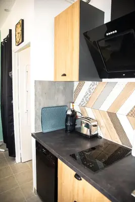 a kitchen with a black counter top with a toaster at le studio du Grazel in Gruissan
