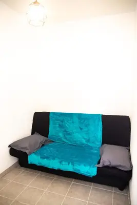 a futon couch in a corner of a room at le studio du Grazel in Gruissan