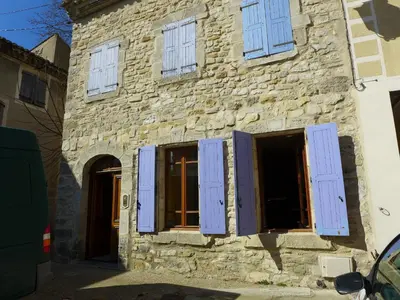 an old stone building with blue shuttered windows at Ferienhaus Le Château in Armissan