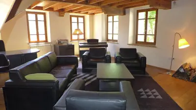 a living room with leather furniture and a table at Ferienhaus Le Château in Armissan