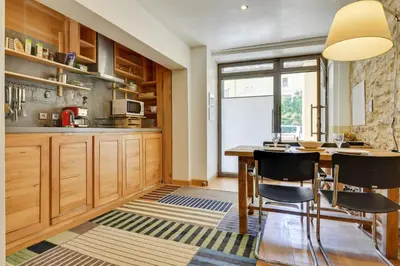 a kitchen with wooden cabinets and a table and chairs at Designer Haus in Armissan