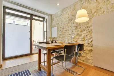a dining room with a wooden table and a stone wall at Designer Haus in Armissan