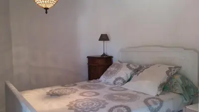 a bed in a room with a lamp and a bed sidx sidx sidx at GITE PAPY ALBERT in Gruissan