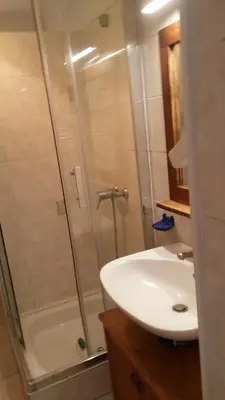 a bathroom with a shower and a white sink at GITE PAPY ALBERT in Gruissan