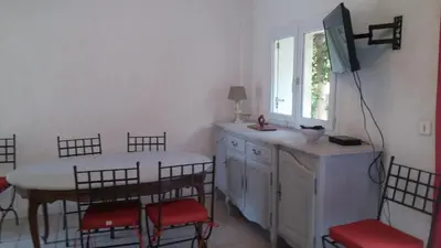a kitchen with a table and chairs and a window at GITE PAPY ALBERT in Gruissan