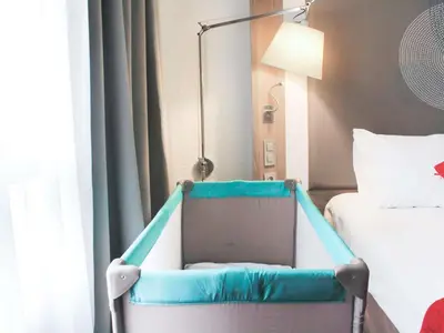 a hospital room with two beds and a chair at Novotel Narbonne Sud A9/A61 in Narbonne