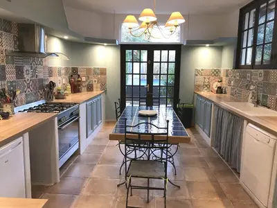a kitchen with a table and chairs in it at Hibiscus House in Carcassonne