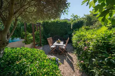 a table and chairs in the middle of a garden at Hibiscus House in Carcassonne