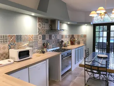 a kitchen with a microwave and a stove top oven at Hibiscus House in Carcassonne