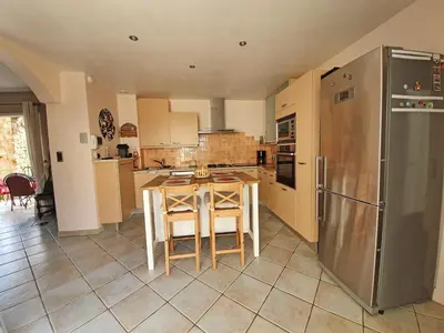 a kitchen with a table and a refrigerator at Stay, Saint-André-de-Roquelongue in Saint-André-de-Roquelongue