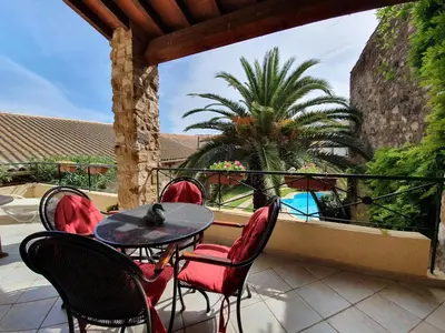 a patio with a table and chairs and a palm tree at Stay, Saint-André-de-Roquelongue in Saint-André-de-Roquelongue