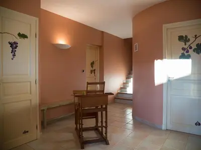a hallway with a door and a chair and a table at Stay, Saint-André-de-Roquelongue in Saint-André-de-Roquelongue