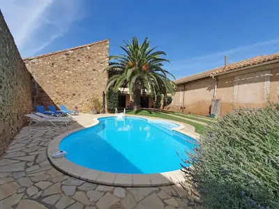 a swimming pool in a yard with two chairs at Stay, Saint-André-de-Roquelongue in Saint-André-de-Roquelongue
