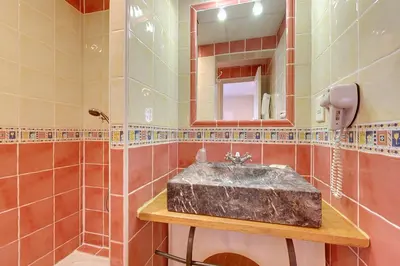 a bathroom with a sink and a mirror at Hotel du Mas in Vinassan