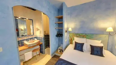 a bedroom with a bed and a bathroom with a sink at Hotel du Mas in Vinassan