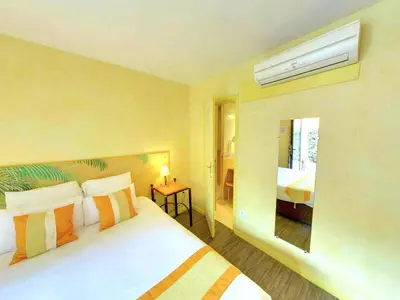 a hotel room with a bed and a window at Hotel du Mas in Vinassan