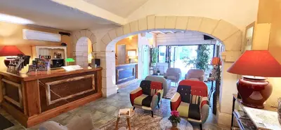 a living room with an archway with chairs and a table at Hotel du Mas in Vinassan