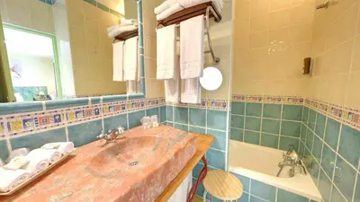 a bathroom with a sink and a tub and a mirror at Hotel du Mas in Vinassan