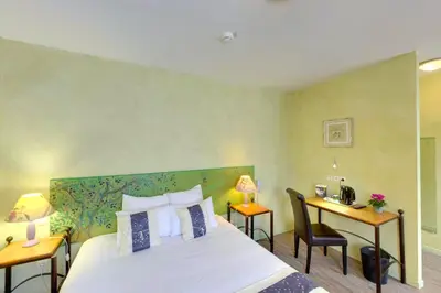 a hotel room with a bed and a desk and a bed at Hotel du Mas in Vinassan