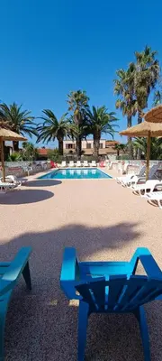 a swimming pool with two chairs and a blue bench at Gite la Capelle près de Sigean Narbonne dans l'Aude à 10 min des plages Méditerranée in Roquefort-des-Corbières