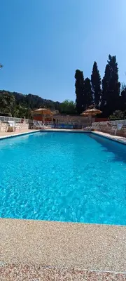 a large swimming pool with blue water at Gite la Capelle près de Sigean Narbonne dans l'Aude à 10 min des plages Méditerranée in Roquefort-des-Corbières