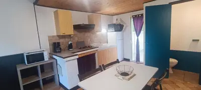 a small kitchen with a sink and a table at Gite la Capelle près de Sigean Narbonne dans l'Aude à 10 min des plages Méditerranée in Roquefort-des-Corbières