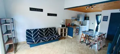 a room with a kitchen and a table and a refrigerator at Gite la Capelle près de Sigean Narbonne dans l'Aude à 10 min des plages Méditerranée in Roquefort-des-Corbières