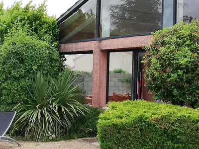 a house with a glass door and some bushes at Maison D architecte chez Huguette in Villalier