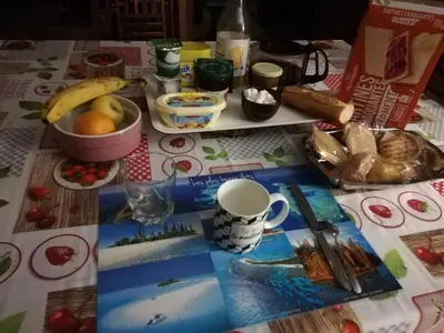 a table with a table cloth with food and a cup at Maison D architecte chez Huguette in Villalier