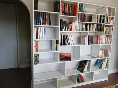 a book shelf filled with books in a room at Maison D architecte chez Huguette in Villalier