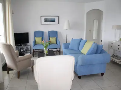 a living room with a blue couch and two chairs at Modern villa in Camplong with private pool in Félines-Minervois