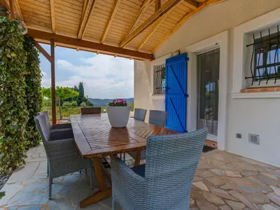 a patio with a wooden table and chairs at Modern villa in Camplong with private pool in Félines-Minervois