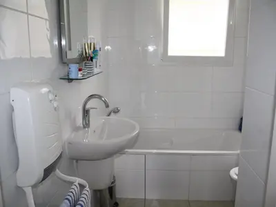 a white bathroom with a sink and a tub at Modern villa in Camplong with private pool in Félines-Minervois