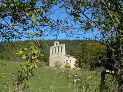 an old stone building in a field with trees at Hôtel De France in Chalabre