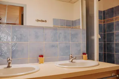a bathroom with two sinks and a mirror at Hôtel De France in Chalabre