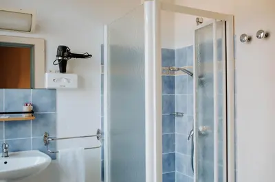 a bathroom with a shower and a sink at Hôtel De France in Chalabre