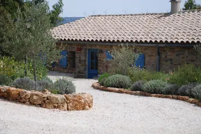 a garden with a stone house and some plants at Bergerie Marcel in Durban-Corbières