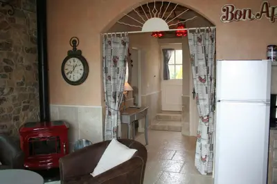 a living room with a refrigerator and a clock on the wall at Bergerie Marcel in Durban-Corbières