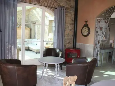 a living room with a table and chairs and a fireplace at Bergerie Marcel in Durban-Corbières