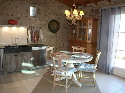 a kitchen with a table and chairs in a room at Bergerie Marcel in Durban-Corbières
