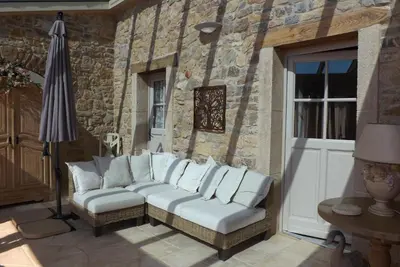 a couch with white pillows sitting on a patio at Bergerie Marcel in Durban-Corbières