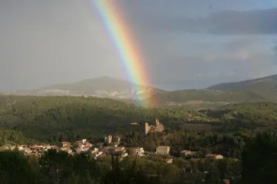 a rainbow over a small town with a castle at Bergerie Marcel in Durban-Corbières
