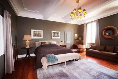 a bedroom with a bed and a couch and a chandelier at La Résidence de Gérard in Montréal