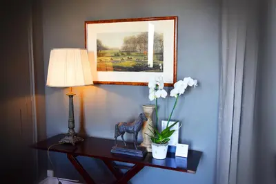 a table with a lamp and a vase of flowers on it at La Résidence de Gérard in Montréal