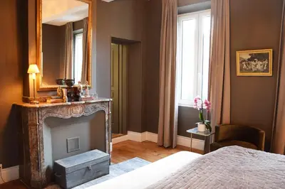 a bedroom with a fireplace and a bed and a mirror at La Résidence de Gérard in Montréal