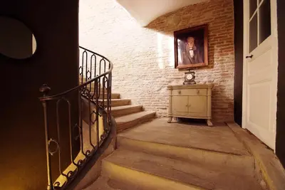 a stairway with a painting on a brick wall at La Résidence de Gérard in Montréal