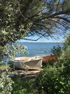 a boat sitting on the shore of a body of water at Appartement moderne, vue imprenable in Bages