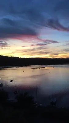a large lake with boats in the water at sunset at Appartement moderne, vue imprenable in Bages