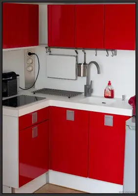 a kitchen with red cabinets and a sink at Appartement moderne, vue imprenable in Bages